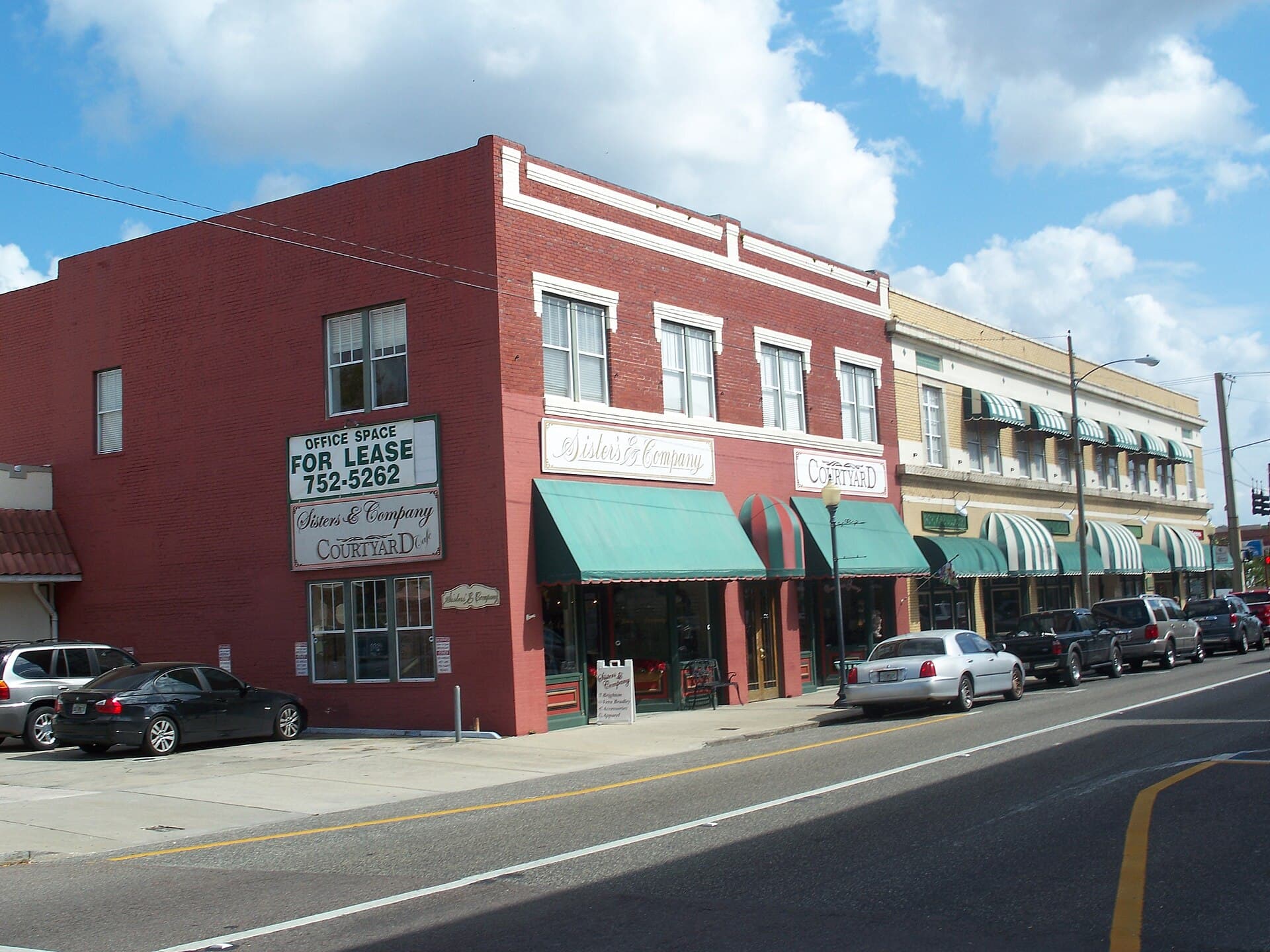 Red-brick shopfronts with green awnings in downtown Plant City